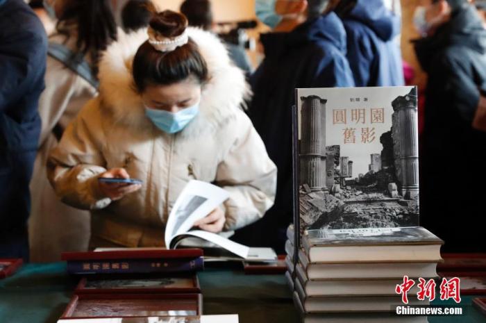 资料图：观众欣赏圆明园老照片书籍。 中新社记者 韩海丹 摄