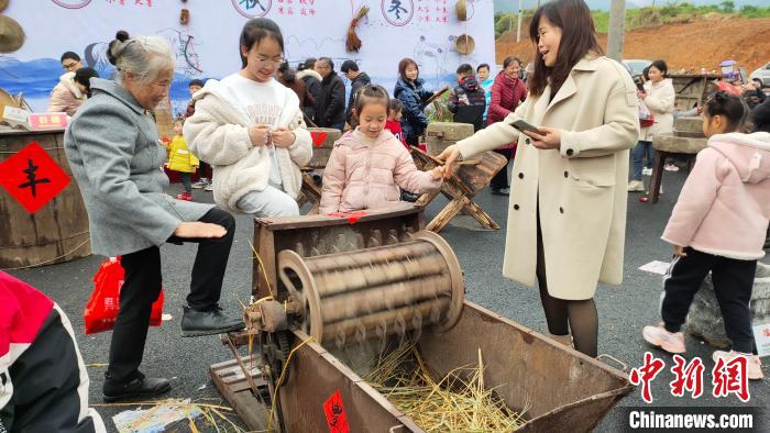 广西灌阳“二月八”农具节上，游客操作农具。　杨宗盛 摄